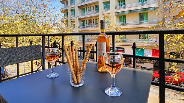 Ein Balkon mit einer Weinflasche, zwei Gläsern und einem Glas Churros.