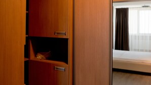 Ein Holzkleiderkasten mit Spiegel, Ablagefläche und Tür.