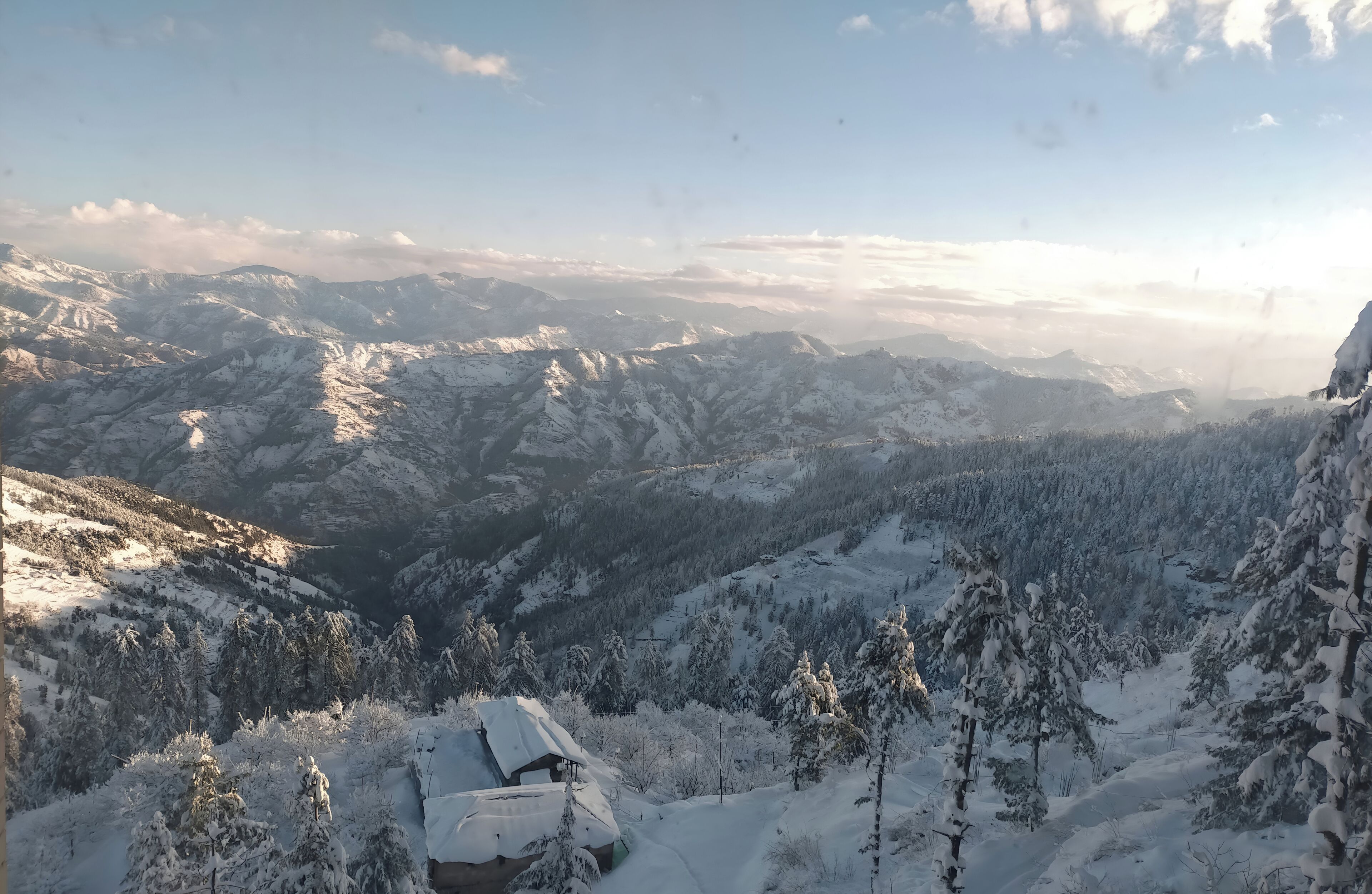 A snow-covered mountain landscape with a cabin.