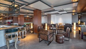 A modern interior with a bar area, seating, and a foosball table. - Radisson Hotel Kufri Shimla (Theog)