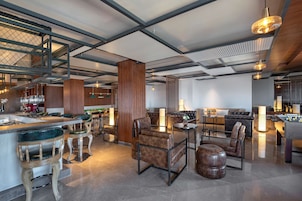 Un interior moderno con una zona de bar, asientos y una mesa de fútbol.
