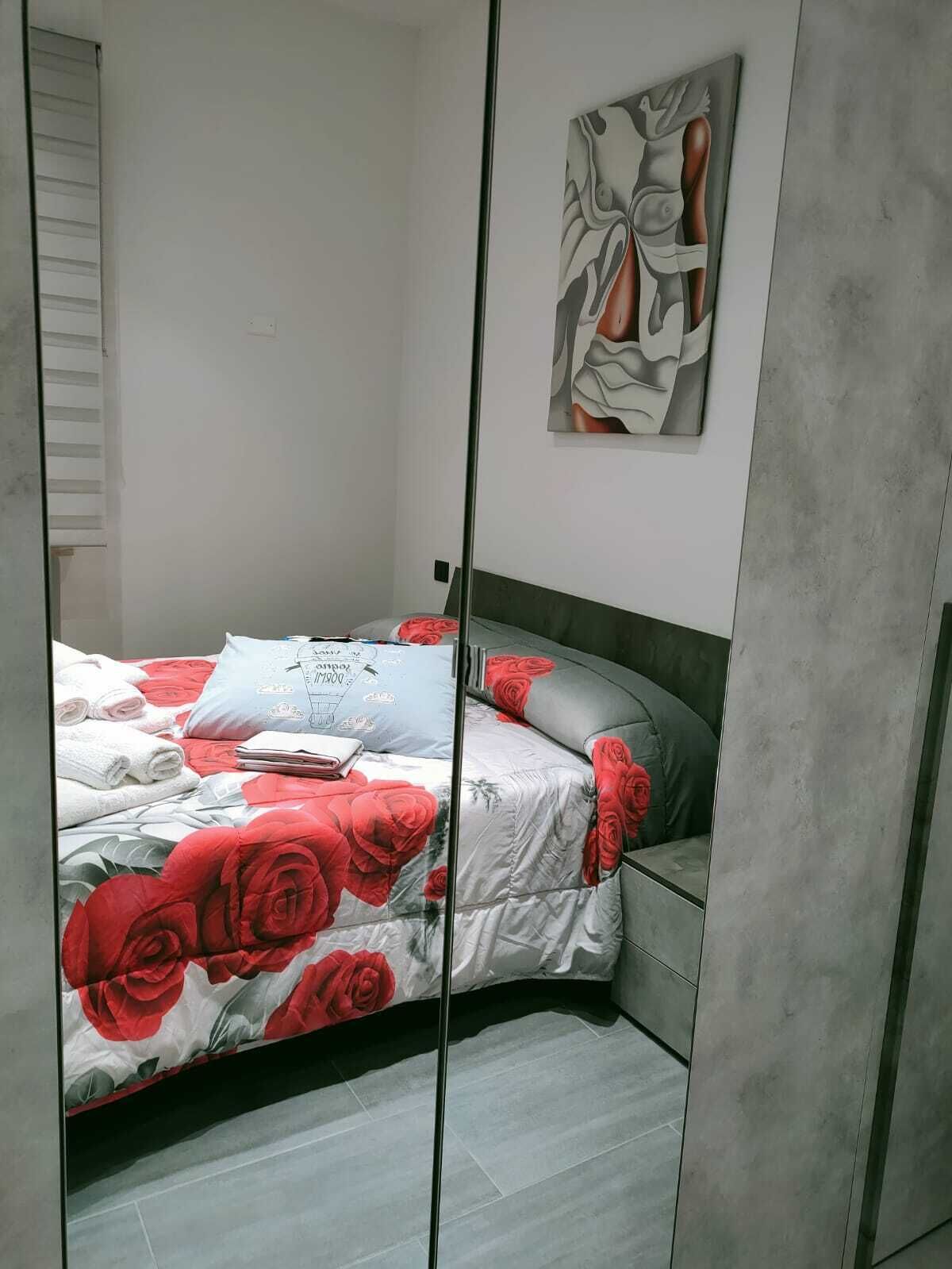 Una camera da letto con un letto, un armadio e un'opera d'arte appesa al muro.