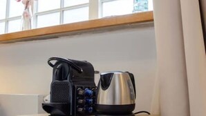 Une table de chevet en bois avec une radio et une bouilloire.