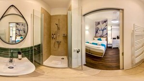 A modern bathroom with a shower, a sink, and a mirror. - Homely Stay Studio1 - Your place to relax (München)