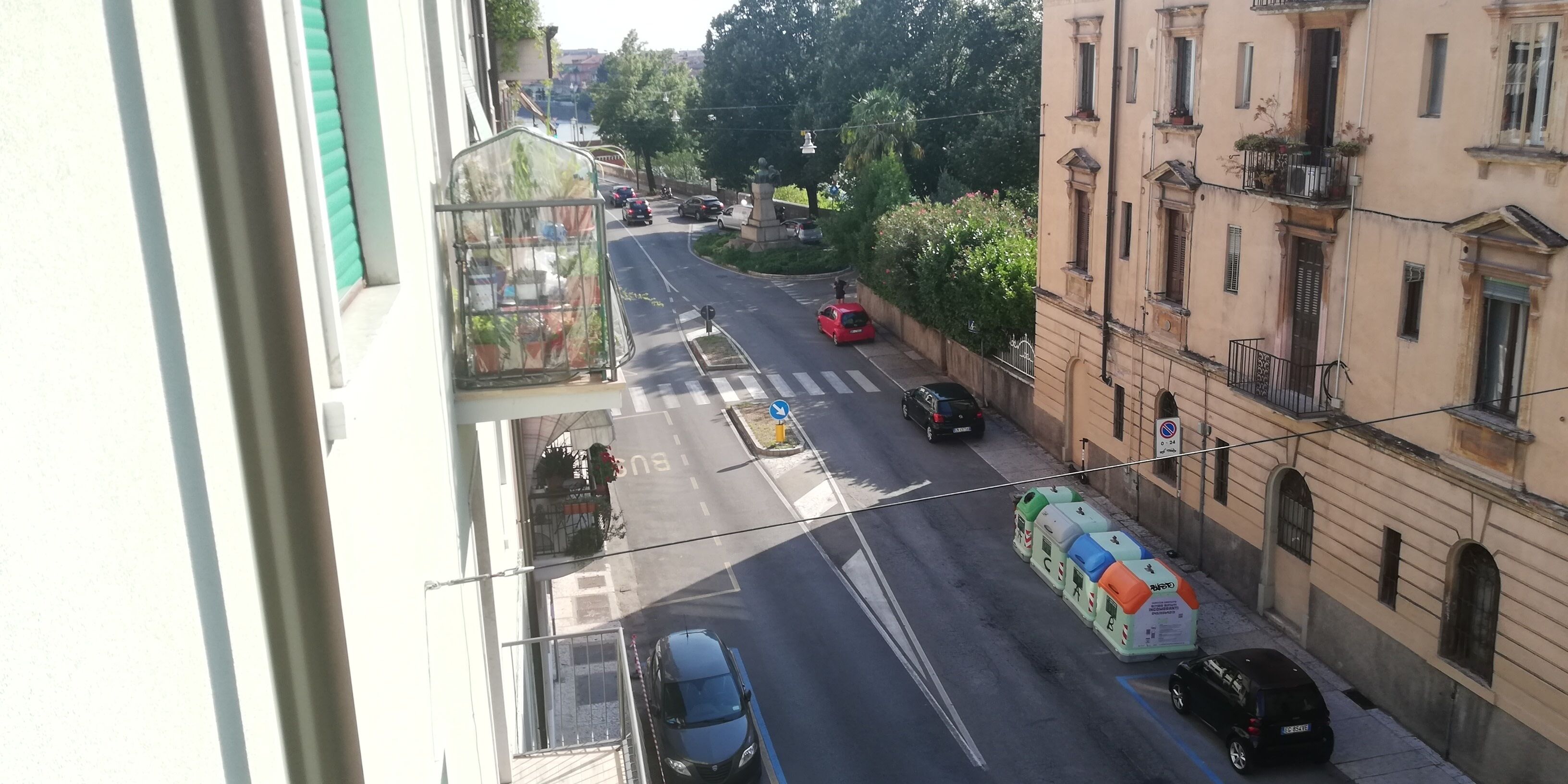 Vista de una calle con edificios, un paso de peatones y automóviles estacionados.