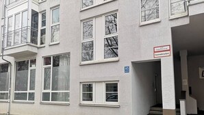 A building with multiple windows, a sign indicating a fire safety exit, and a visible entrance. - Homely Stay Studio6 - Modern with feel-good factor (München)