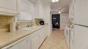 A compact kitchen with white cabinets, a double sink, and a black countertop. - ★ Good Vibes Ranch ★ Walk to Zoo | Pet Friendly (West Columbia)