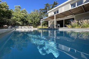 A modern house with a swimming pool, outdoor seating, and a covered patio area. - Villa between sea and golf with swimming pool for 9 people (Saint-Raphaël)
