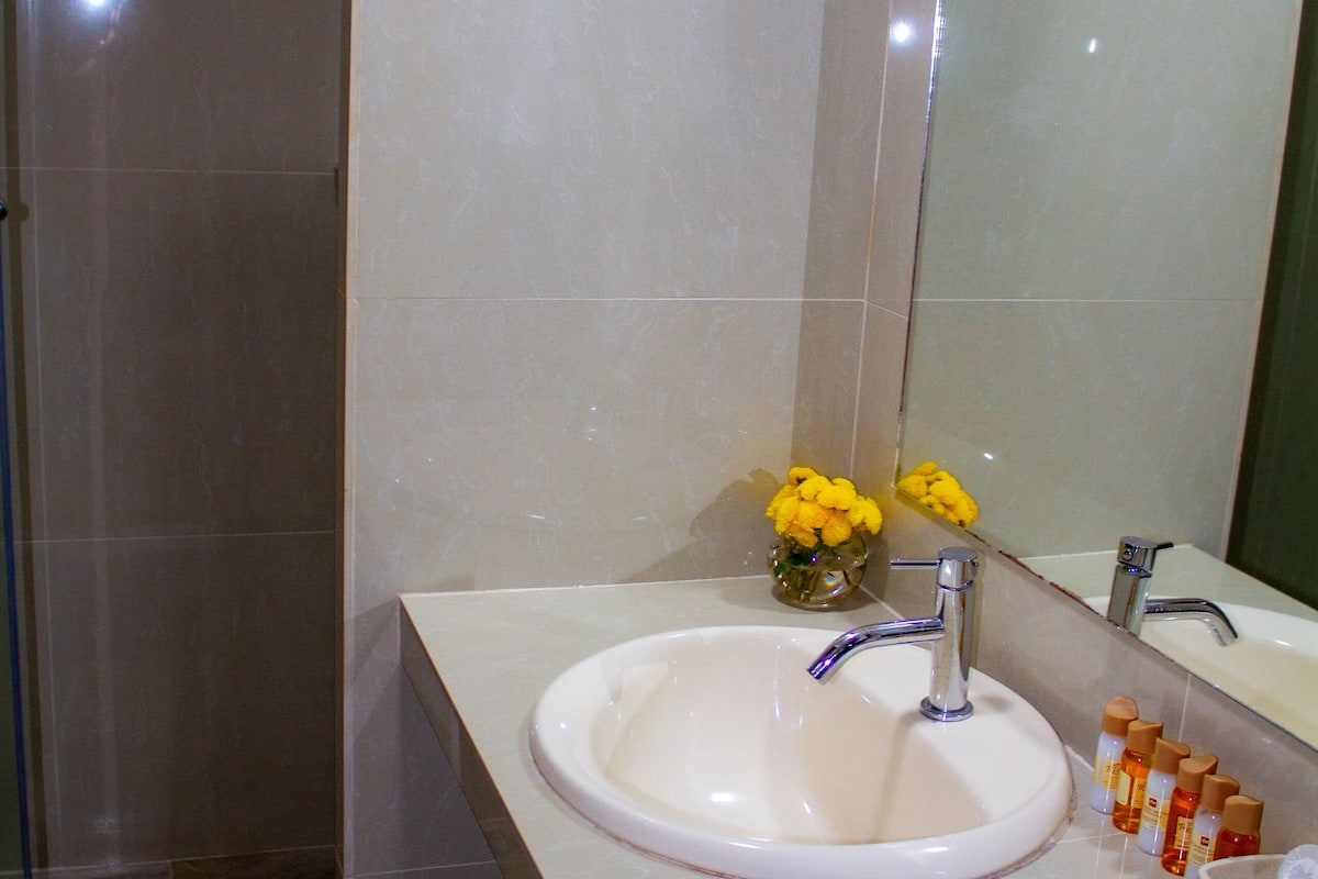 superior single room | bathroom | shower, rainfall showerhead, hair dryer, towels