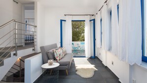 Un intérieur moderne avec un canapé gris, une petite table ronde et un escalier doté de rampes en métal.