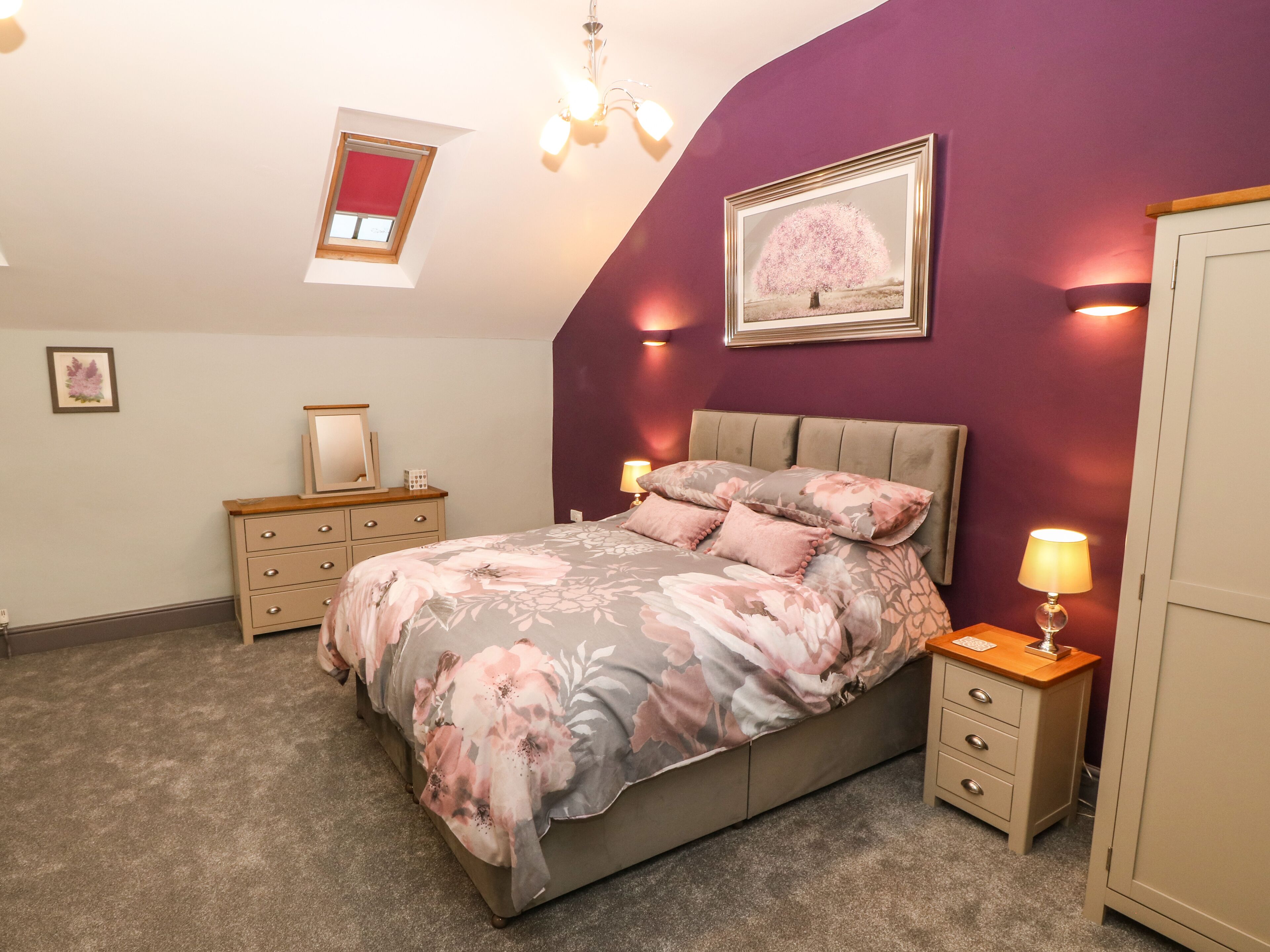 A bedroom with a bed, nightstands, a dresser, a ceiling light, a window, and a framed picture on the wall.