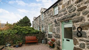 A stone building with a green door labeled "Bryan Baker Bath." - Bryn Aber Bach (Pwllheli)