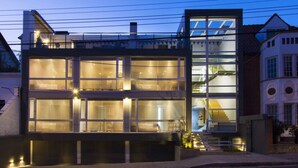 A modern two-story house with large windows and a visible staircase leading to the upper floor.