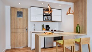 A modern kitchen with wooden cabinetry, a built-in microwave, and a dining area with a wooden table and chairs.