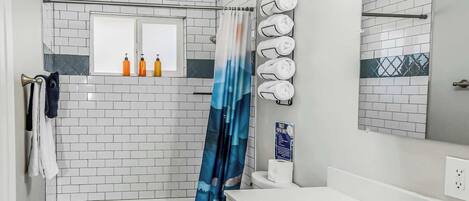 Bathtub, hair dryer, towels, shampoo
