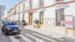 Un bâtiment sur lequel on peut lire l’inscription « AYUNTAMIENTO » et où flottent de nombreux drapeaux. Une voiture est garée devant.