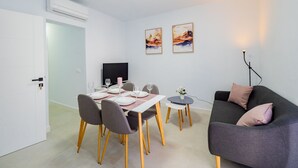Un salon moderne comprenant un coin repas, un canapé et un téléviseur.