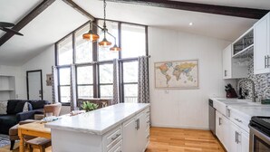 A modern kitchen with a large island, wooden flooring, and a world map on the wall. - Pet friendly/walk to restaurant/bar and golf  (Flagstaff)