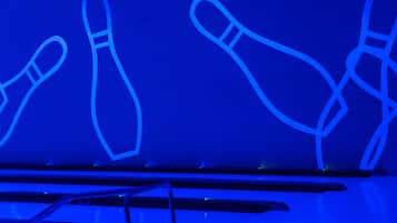 A bowling alley with illuminated bowling pins.