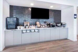 A modern kitchen with a flat-screen TV, built-in appliances, and ample storage.