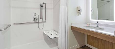 A modern bathroom with a walk-in shower, a vanity with a mirror, and a toilet.