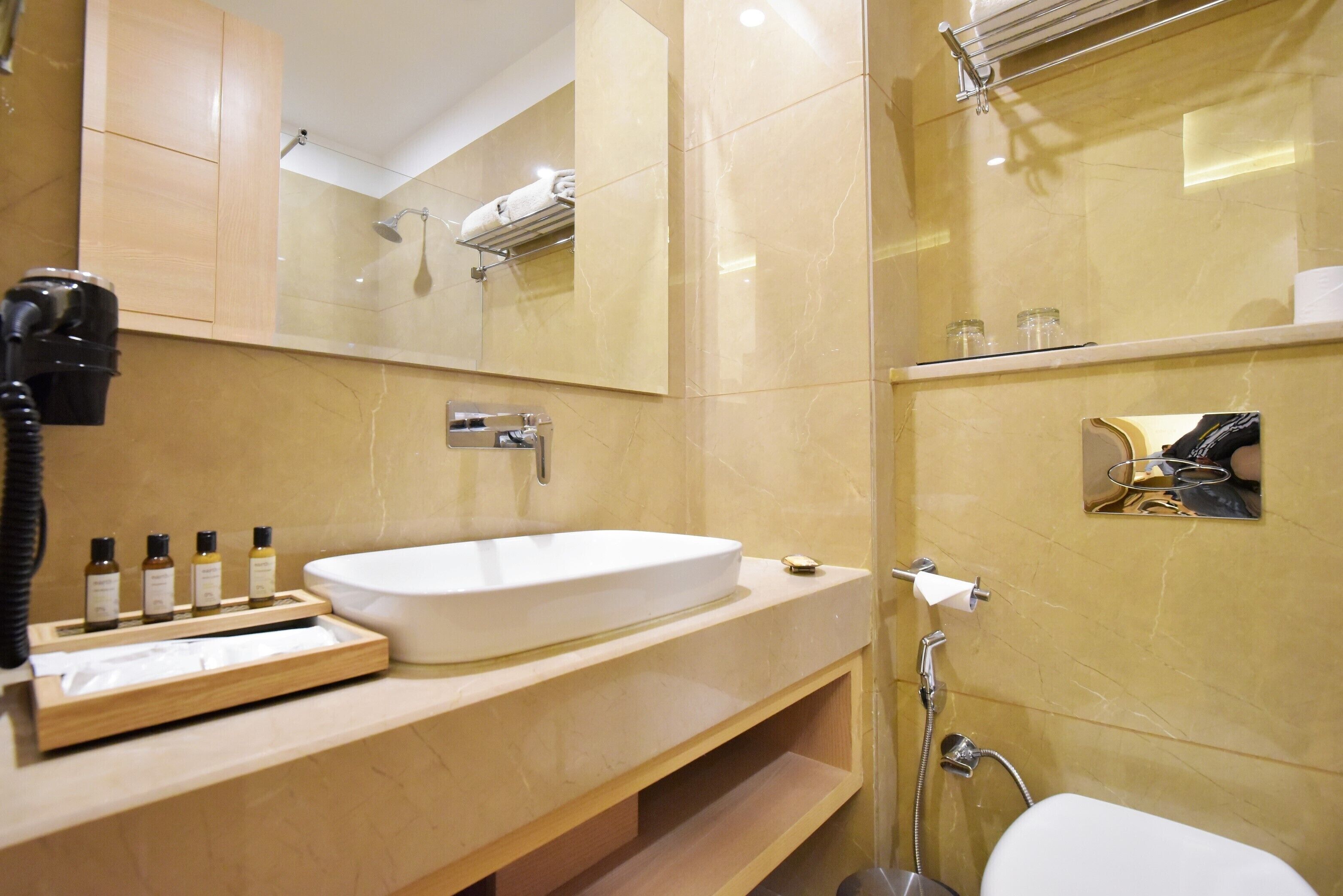 A modern bathroom with a large sink, a mirror, and a shower.