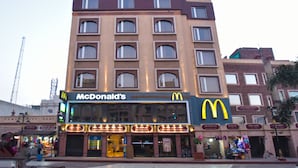 Un immeuble à plusieurs étages qui abrite un restaurant McDonald's au rez-de-chaussée.