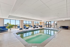 Una piscina coberta amb gandules i vista al mar.