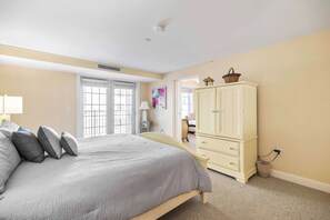Ein Schlafzimmer mit Bett, Kleiderschrank, Lampe und einem Gemälde.