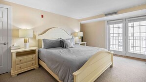 A bedroom with a bed, bedside tables, and a window.