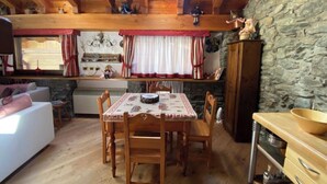 A cozy interior with a dining area, kitchen, and living space. - Entire Chalet with fireplace. garden, Wi-Fi, adjacent to village center (Paquier)