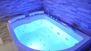 Ein modernes Badezimmer mit einer freistehenden Badewanne, einer Dusche und einer Fliesenwand.