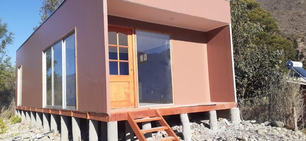 Un edificio moderno a un piano, con ampie finestre e una porta in legno.