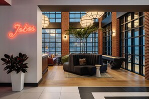 A modern lounge area with a neon sign, large windows, and a pool table. - Hotel Tupelo, a Wyndham Hotel (Tupelo)