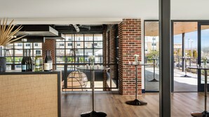 A modern interior with a brick wall, large windows, and a wooden floor.