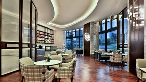 A spacious indoor area with multiple seating arrangements, large windows, and a modern ceiling design. - Wyndham Garden Hangzhou Yuhang (Hangzhou)
