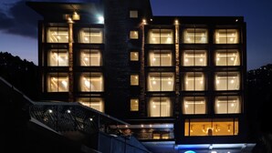 Un hotel moderno con varios pisos, grandes ventanales y un llamativo letrero de 'Best Western'.