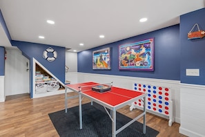 A room with a ping pong table, artwork on the walls, and a bookshelf. - Lakefront Home-Stunning Views-Hot Tub, 3100 sqft! (Wakefield)