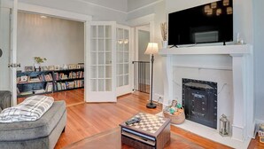 A living room with a fireplace, a television, a bookshelf, and a sofa.