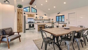 A modern kitchen with a central island, wooden accents, and pendant lighting. - Family Relaxation: Private Pool & Spa with Games (Austin)