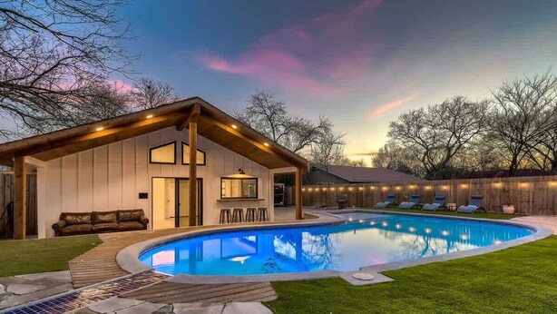 A modern house with a swimming pool, a covered patio, and a well-maintained lawn. - Family Relaxation: Private Pool & Spa with Games (Austin)