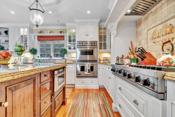 Enjoy cooking in this well-equipped kitchen with a central island, sink, and stainless steel range hood.