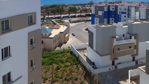 A residential area with modern buildings, a clear blue sky, and a view of the sea. - anza appartement (Agadir)