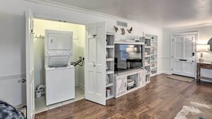 Een moderne keuken met een inbouwoven en magnetron, een witte deur en een houten vloer.