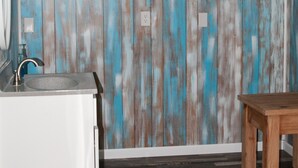 A bathroom with a rustic wooden wall, a sink, and a wooden bench. - Cedar Mountain Lodge (Bryant)