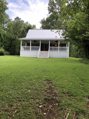 Enjoy a peaceful retreat in this charming house with a covered porch, perfect for relaxing.