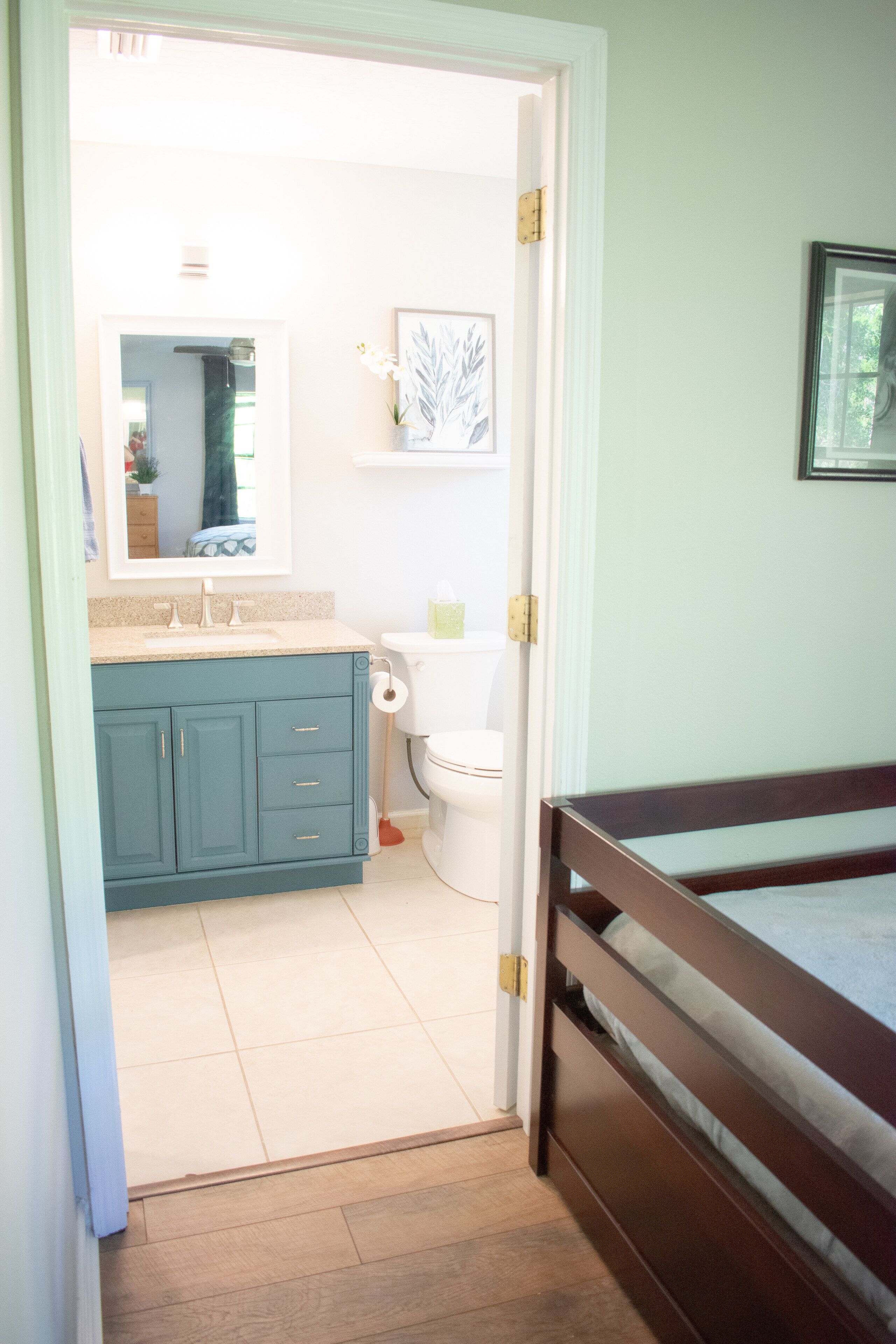 A bathroom with a toilet, sink, and cabinet.