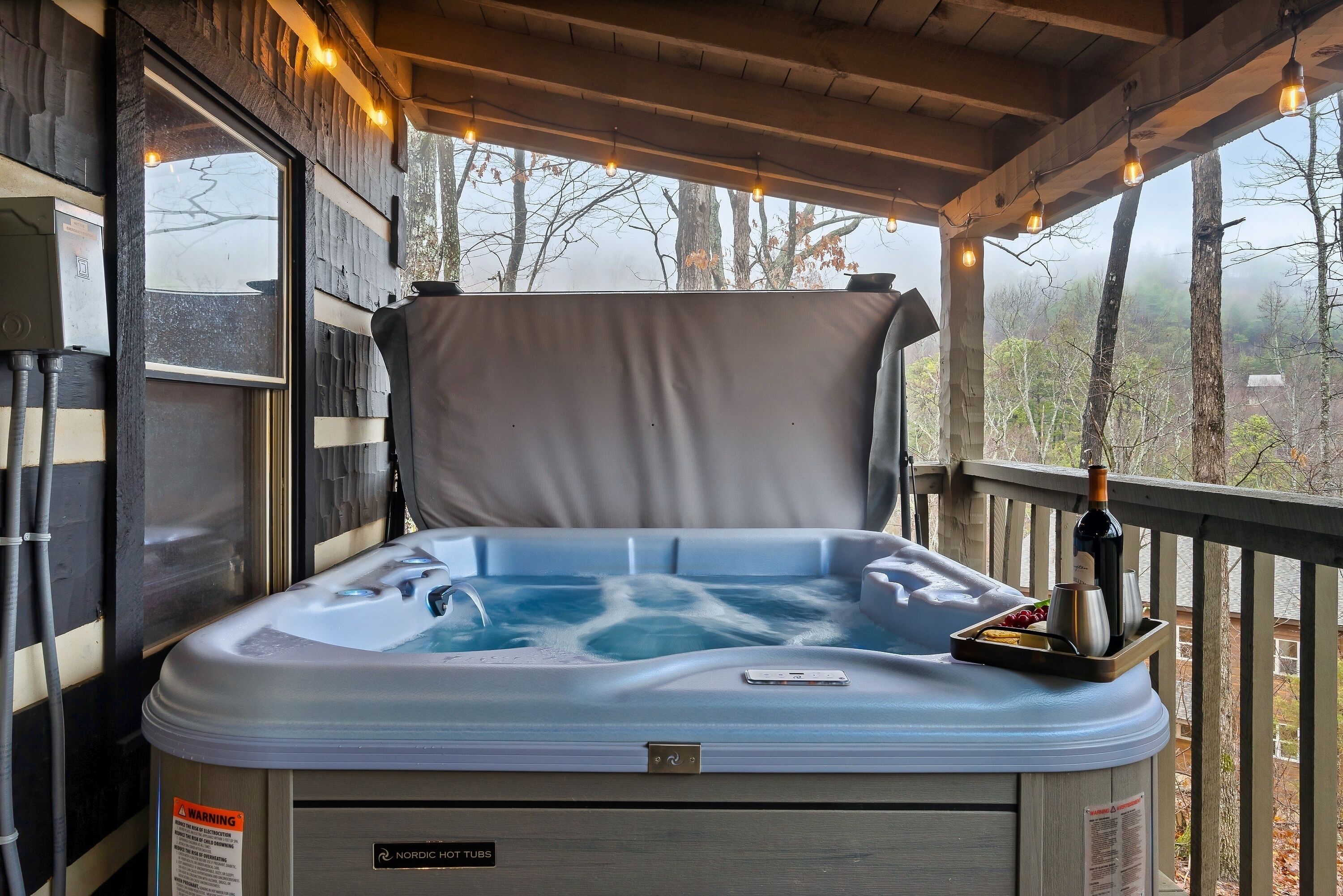 Un jacuzzi con terraza de madera y vista a los árboles.