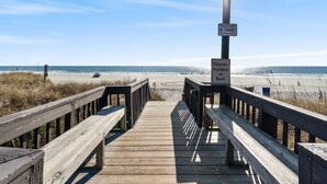 A wooden boardwalk leading to a beach with a sign prohibiting fireworks. - OCEAN VIEW- PETS ALLOWED! (Myrtle Beach)
