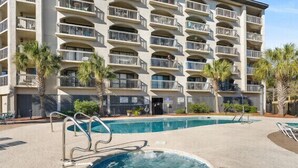 A multi-story hotel with a swimming pool and palm trees. - OCEAN VIEW- PETS ALLOWED! (Myrtle Beach)